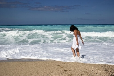 ワンピース姿で海に浸る女性